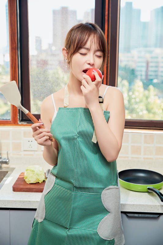 在厨房下厨做饭的年轻亚洲女性图片