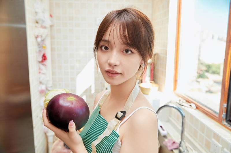 在厨房下厨做饭的年轻亚洲女性图片