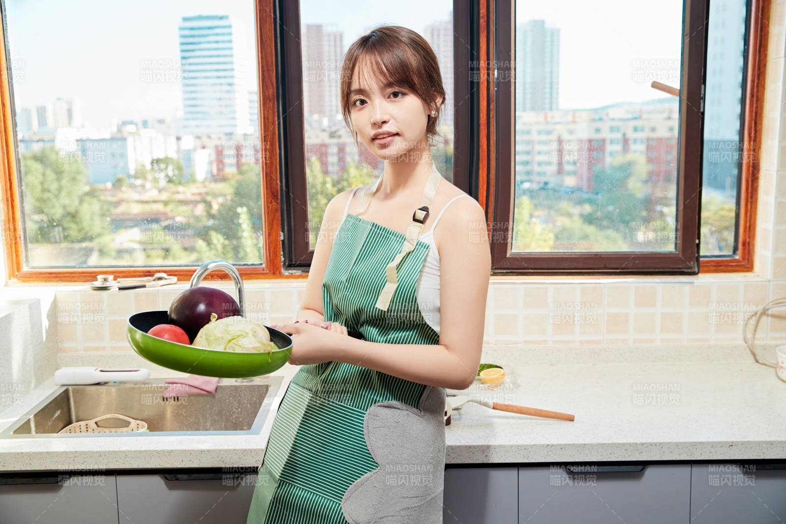 在厨房下厨做饭的年轻亚洲女性图片