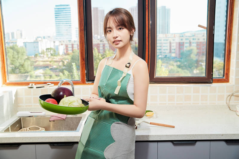 在厨房下厨做饭的年轻亚洲女性图片