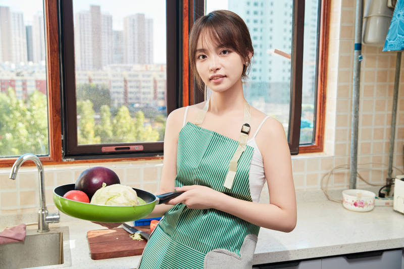 在厨房下厨做饭的年轻亚洲女性图片