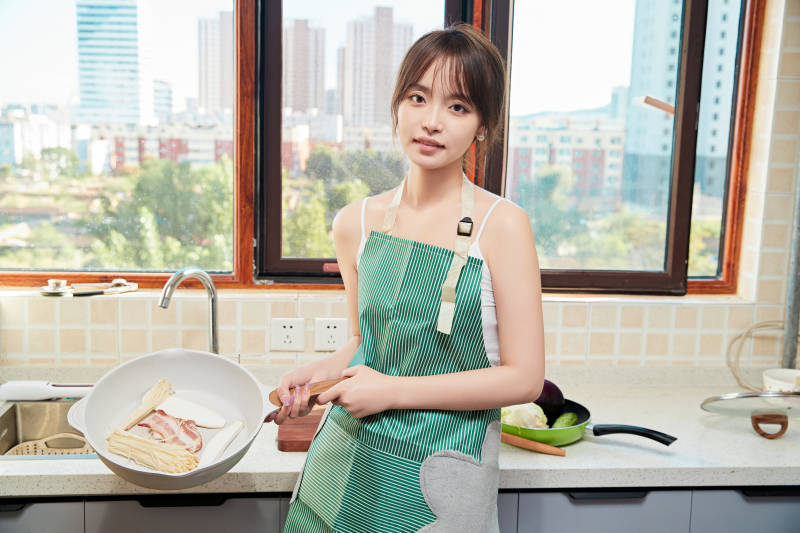 在厨房下厨做饭的年轻亚洲女性图片