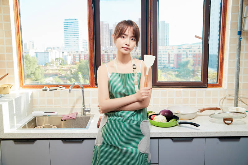 在厨房下厨做饭的年轻亚洲女性图片