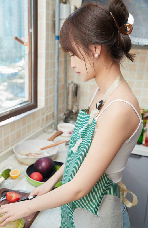 在厨房下厨做饭的年轻亚洲女性图片