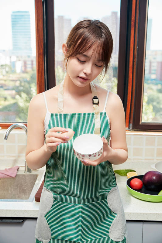 在厨房下厨做饭的年轻亚洲女性图片