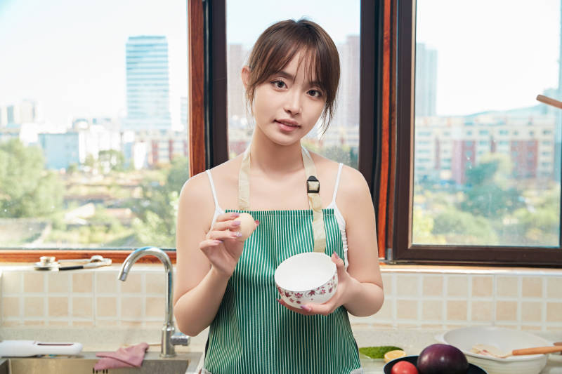 在厨房下厨做饭的年轻亚洲女性图片