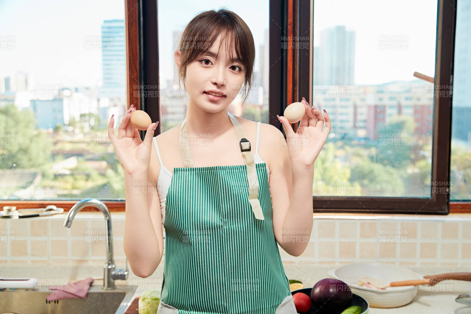 在厨房下厨做饭的年轻亚洲女性图片