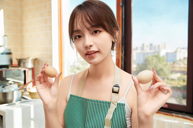 在厨房下厨做饭的年轻亚洲女性图片