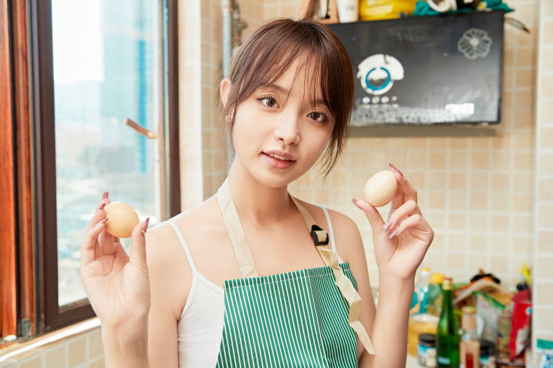 在厨房下厨做饭的年轻亚洲女性图片