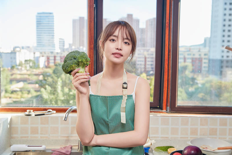 在厨房下厨做饭的年轻亚洲女性图片