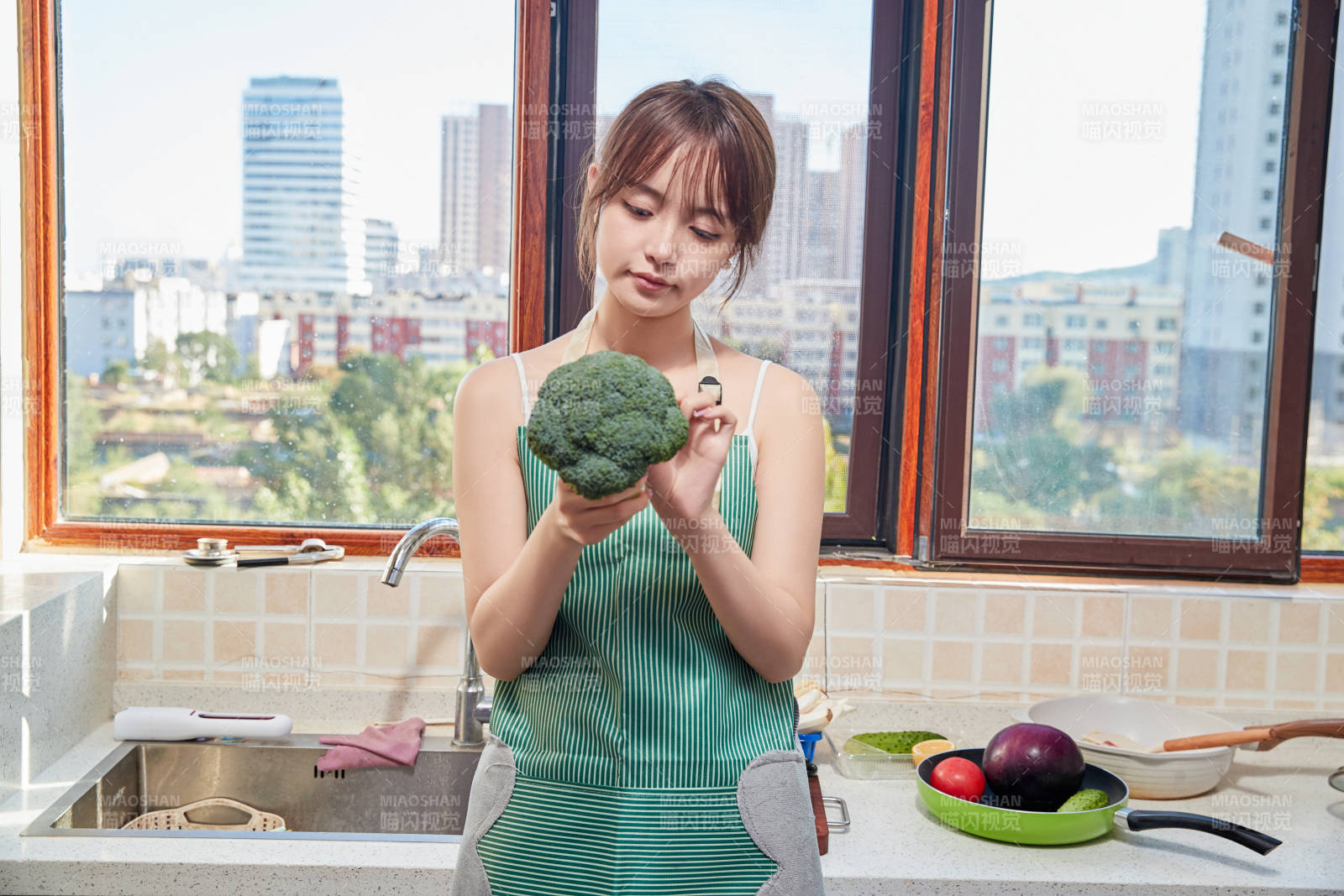 在厨房下厨做饭的年轻亚洲女性图片