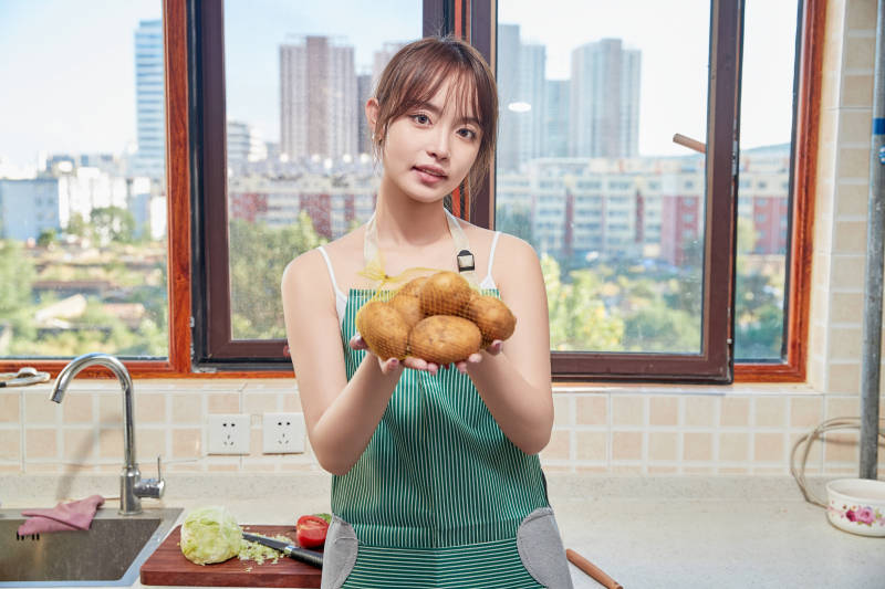 在厨房下厨做饭的年轻亚洲女性图片