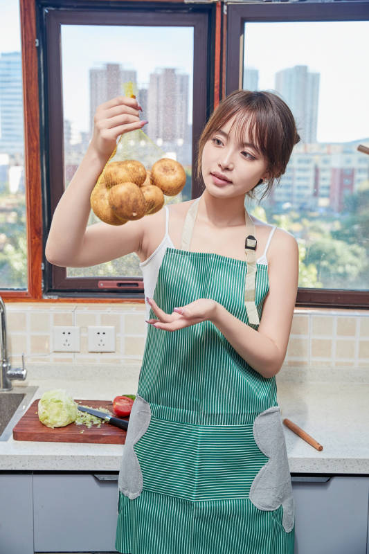 在厨房下厨做饭的年轻亚洲女性图片