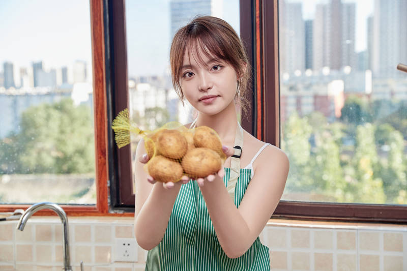 在厨房下厨做饭的年轻亚洲女性图片