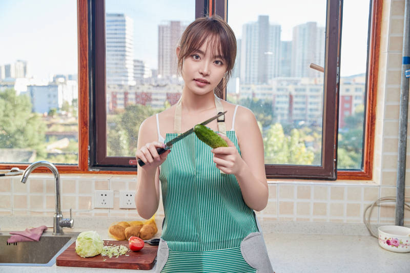 在厨房下厨做饭的年轻亚洲女性图片