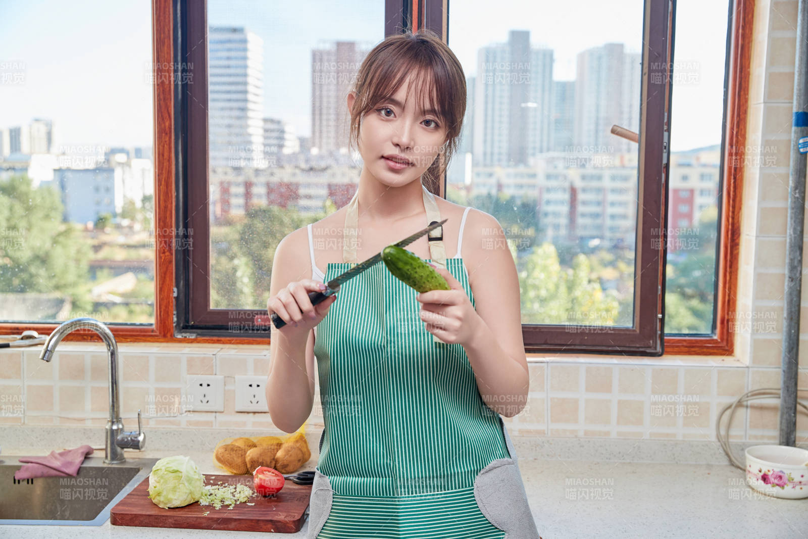 在厨房下厨做饭的年轻亚洲女性图片