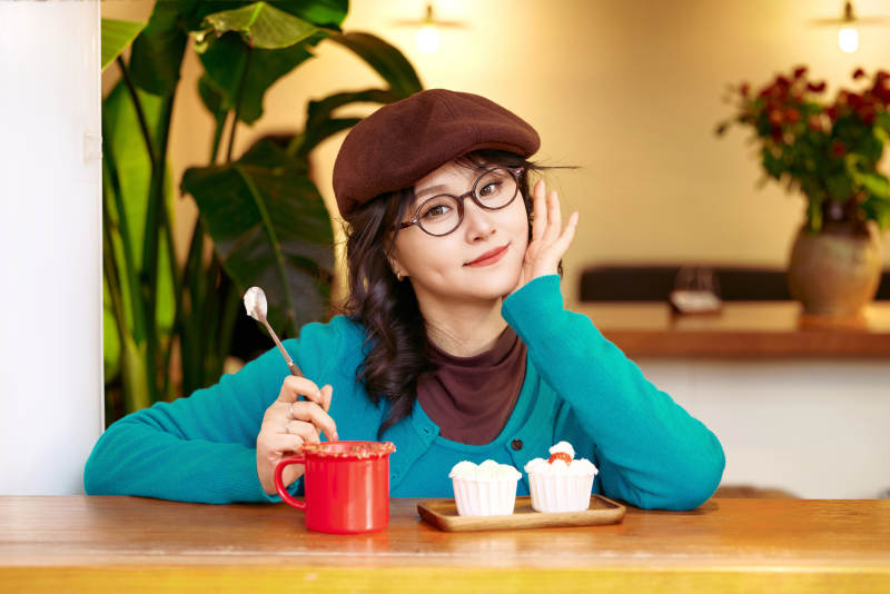 冬日午后坐在咖啡店吃蛋糕喝咖啡的亚洲美女图片