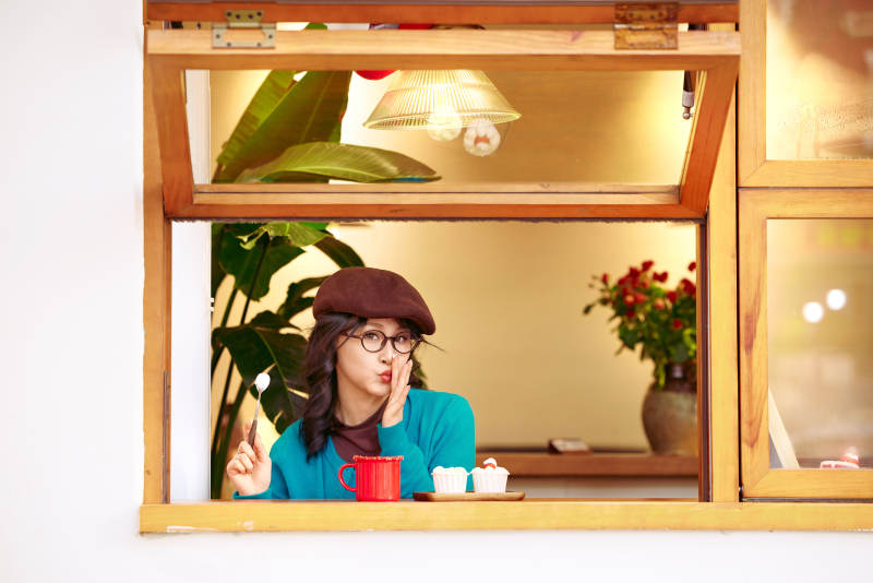 冬日午后坐在咖啡店吃蛋糕喝咖啡的亚洲美女图片