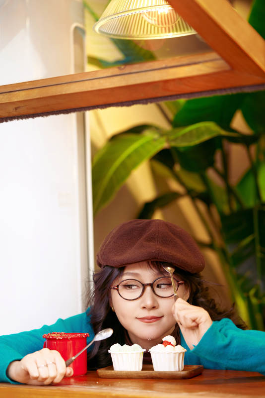 冬日午后坐在咖啡店吃蛋糕喝咖啡的亚洲美女图片