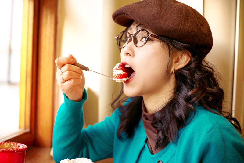 冬日午后坐在咖啡店吃蛋糕喝咖啡的亚洲美女图片