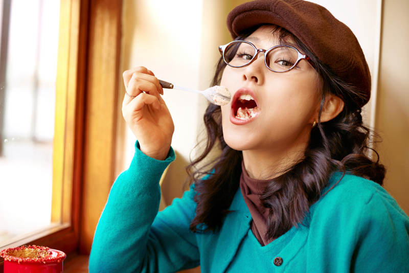 冬日午后坐在咖啡店吃蛋糕喝咖啡的亚洲美女图片