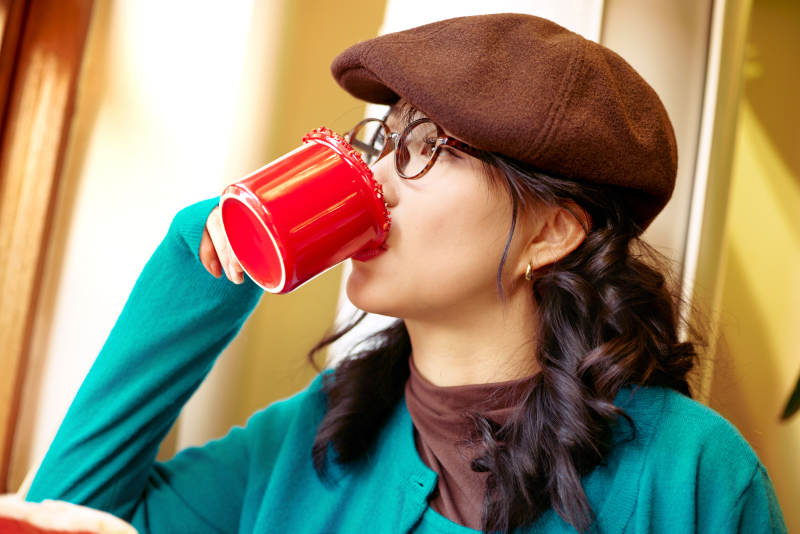 冬日午后坐在咖啡店吃蛋糕喝咖啡的亚洲美女图片