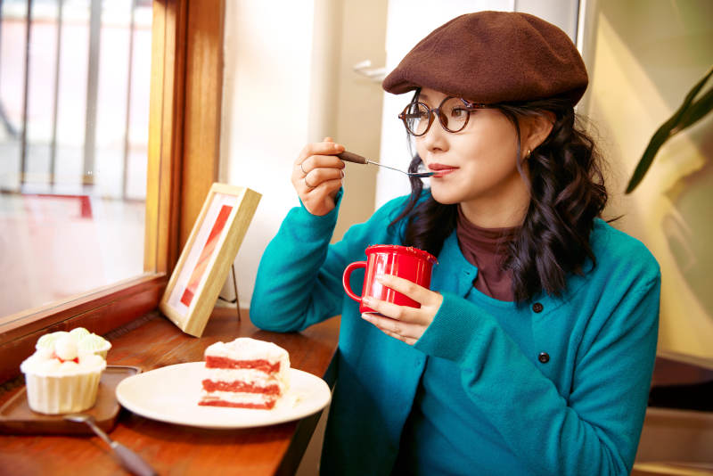 冬日午后坐在咖啡店吃蛋糕喝咖啡的亚洲美女图片