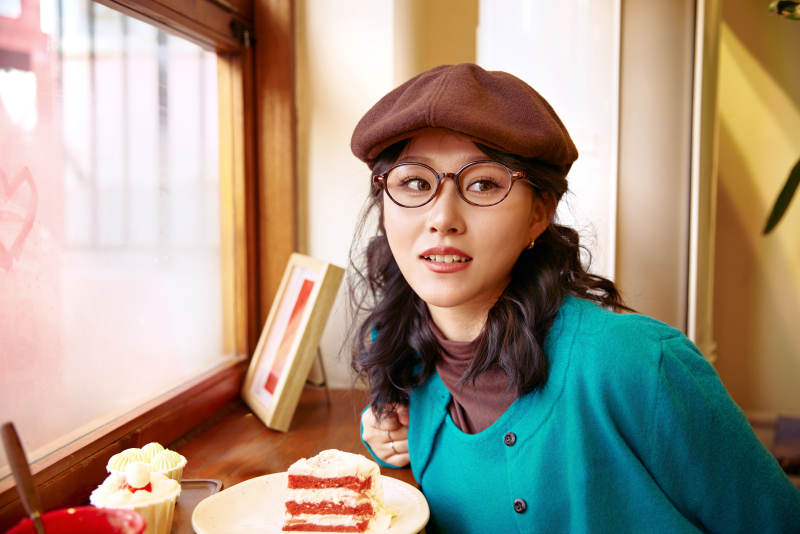 冬日午后坐在咖啡店吃蛋糕喝咖啡的亚洲美女图片