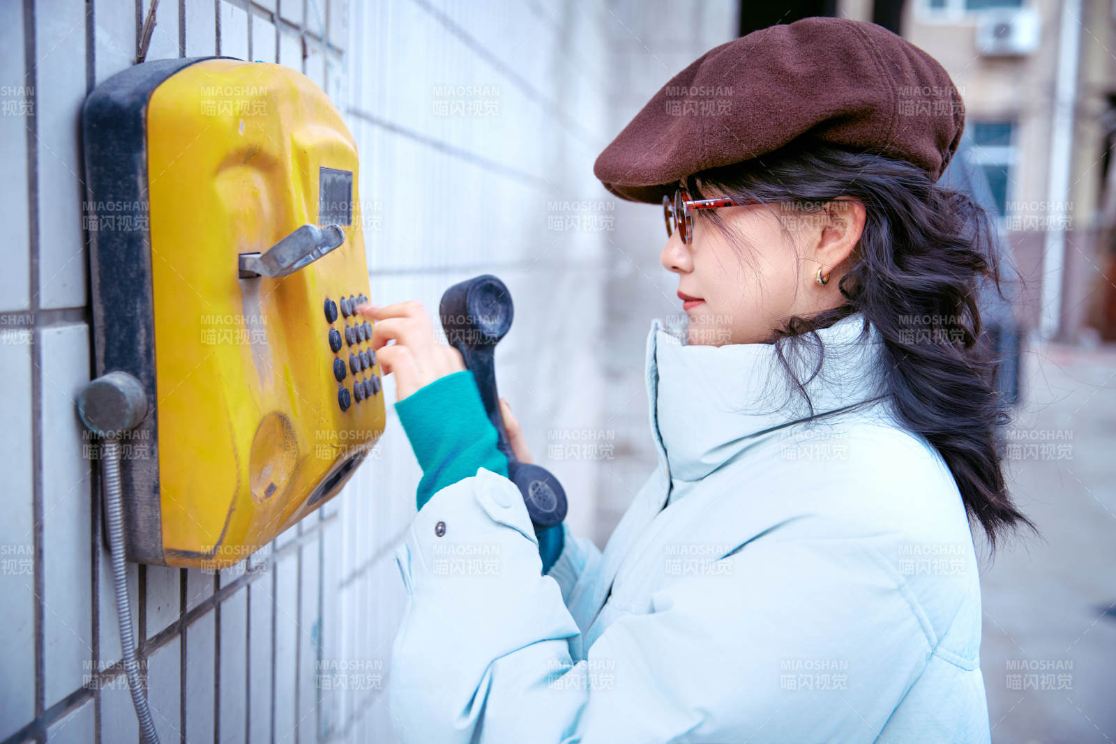 在老旧社区院落回拨打IC卡电话的美女图片