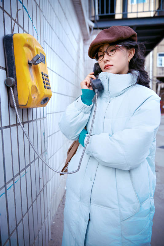 在老旧社区院落回拨打IC卡电话的美女图片