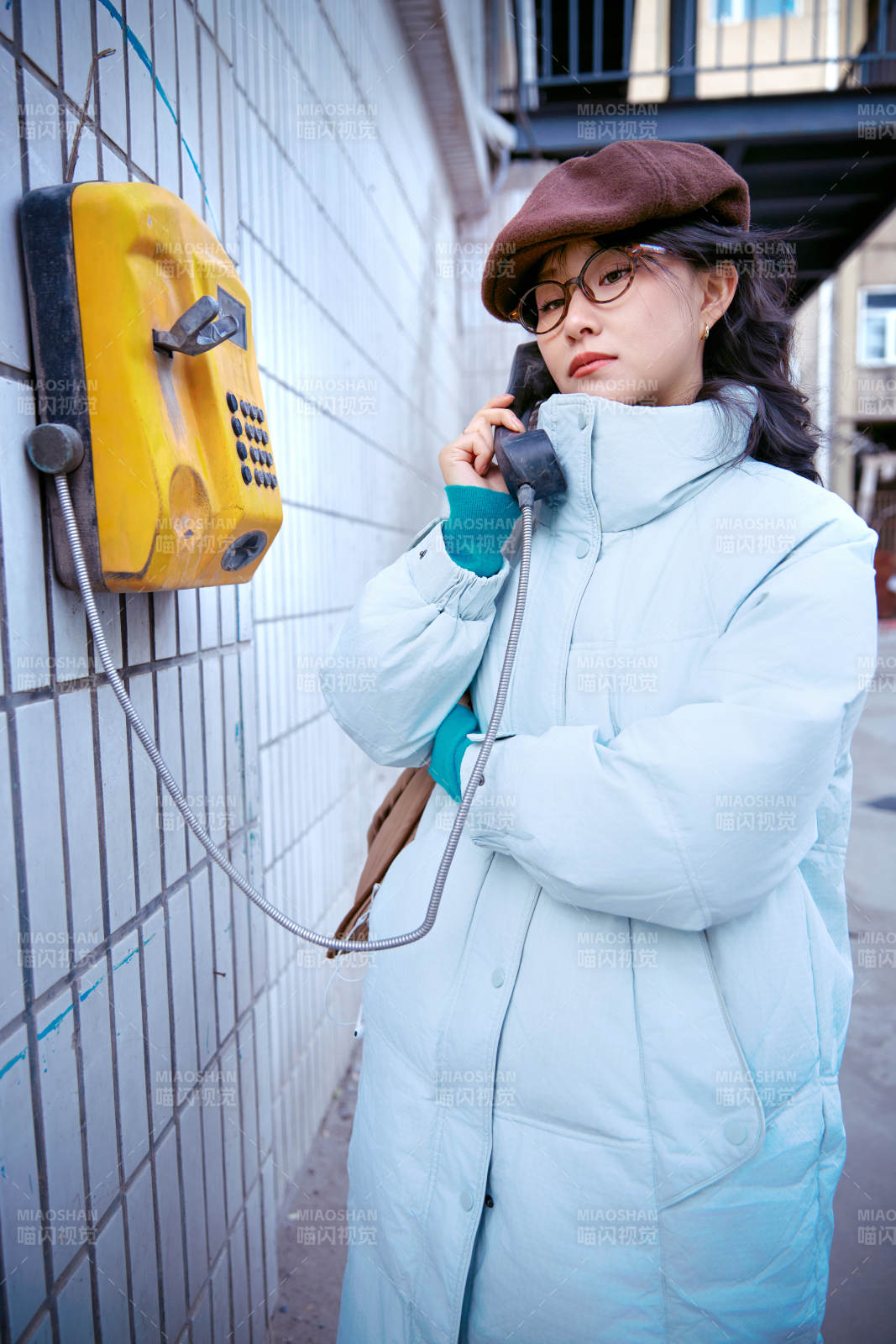 在老旧社区院落回拨打IC卡电话的美女图片