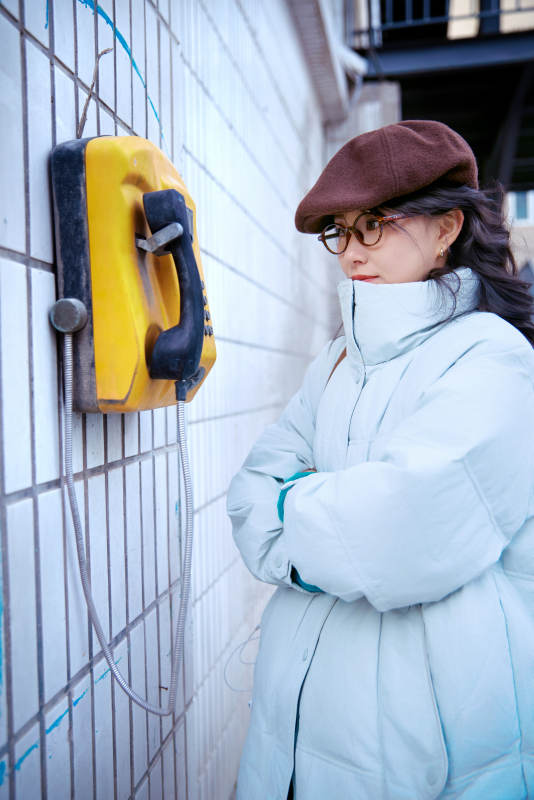 在老旧社区院落回拨打IC卡电话的美女图片