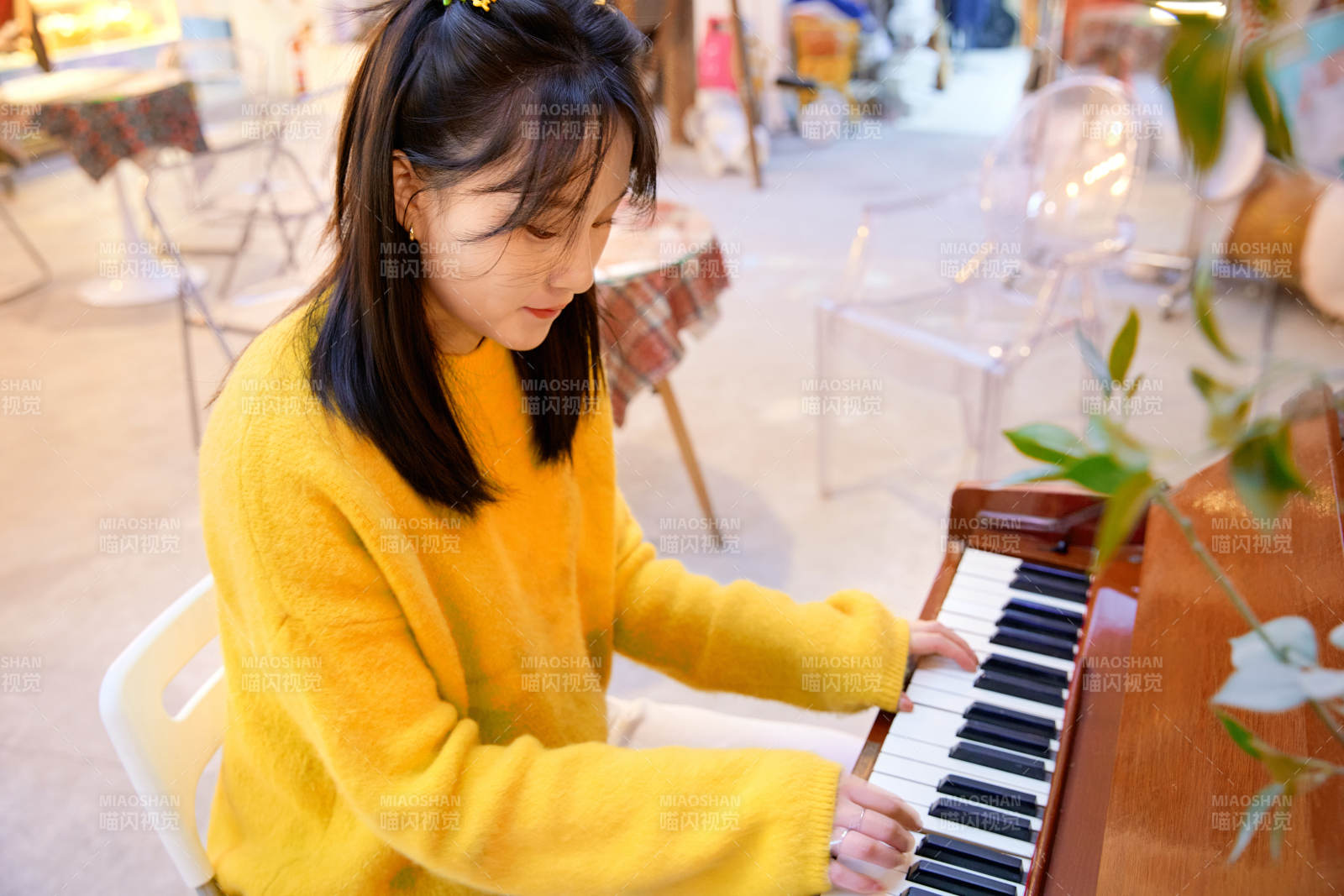 在咖啡店演奏钢琴的东方美女图片