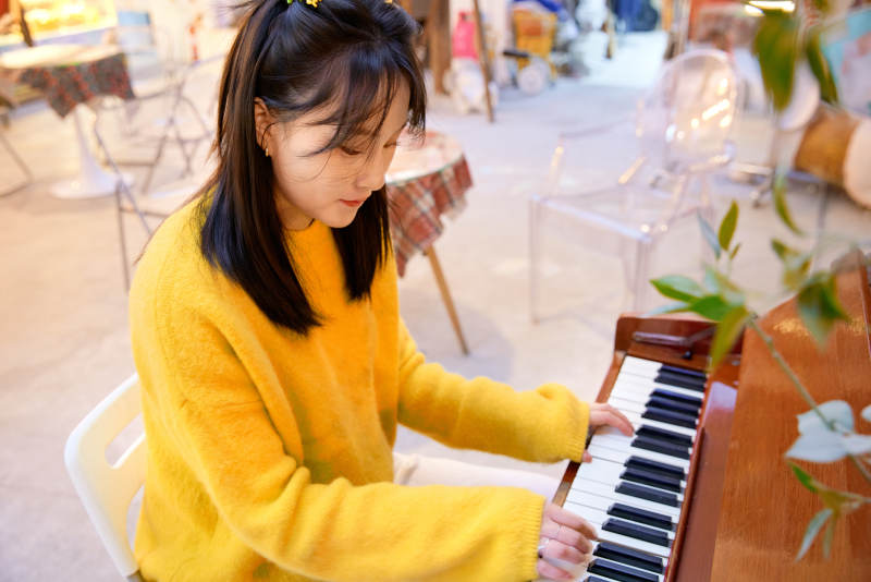 在咖啡店演奏钢琴的东方美女图片