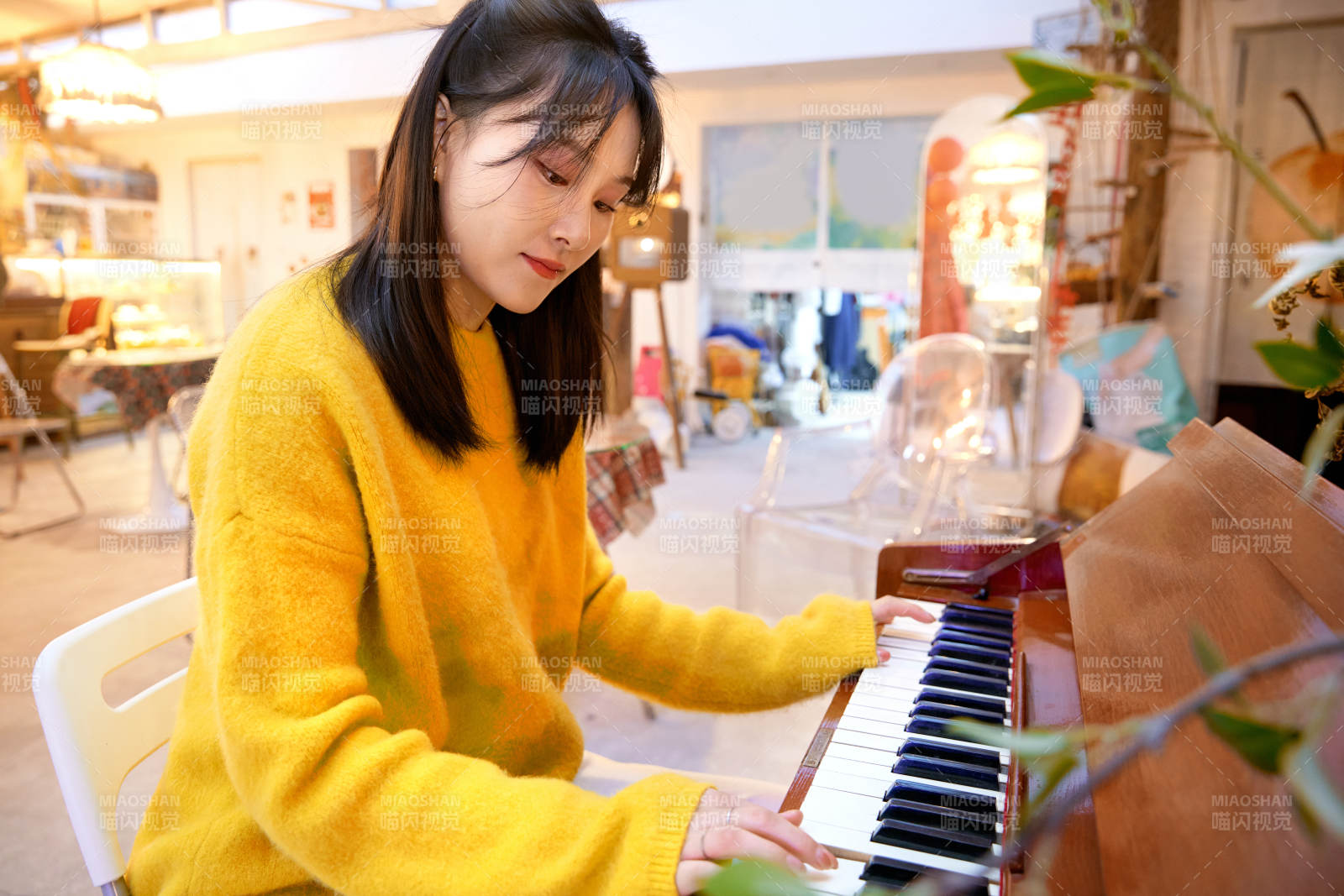 在咖啡店演奏钢琴的东方美女图片