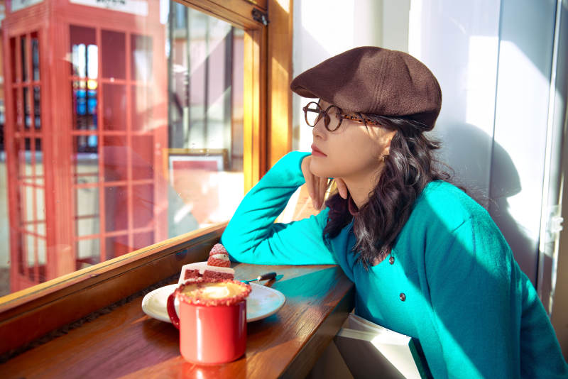 冬日午后坐在咖啡店吃蛋糕喝咖啡的亚洲美女图片