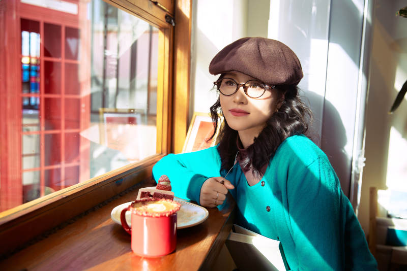 冬日午后坐在咖啡店吃蛋糕喝咖啡的亚洲美女图片