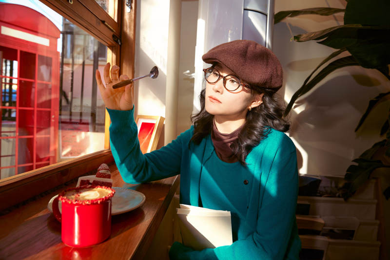 冬日午后坐在咖啡店吃蛋糕喝咖啡的亚洲美女图片