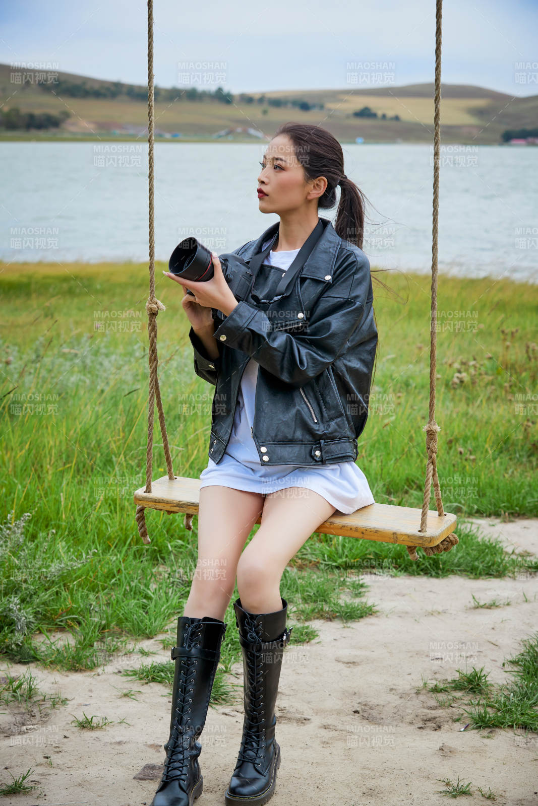 户外湖畔进行拍摄的亚洲青年女性摄影师图片