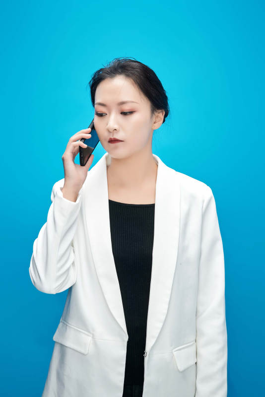 身穿西服拿着手机与文件夹的亚洲商务女士图片