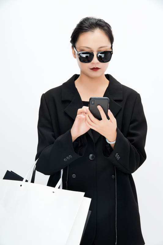 白色背景下手提购物袋时尚美丽的亚洲少女图片