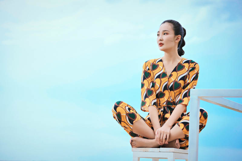 悠闲的坐在美丽湖岸码头的亚洲年轻女性人像图片