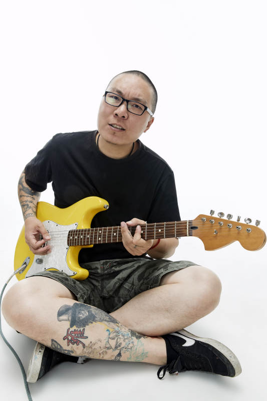 手持电吉他展示演奏的亚洲男性摇滚乐手人像图片