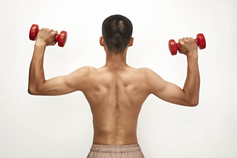 使用哑铃进行健身锻炼的亚洲男性图片