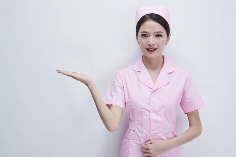 身穿粉色护士服佩戴听诊器的女性医护人员图片