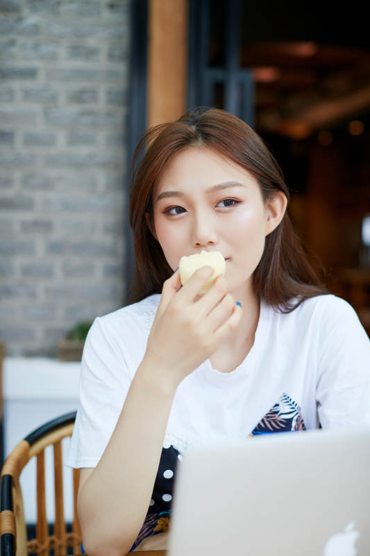 坐在咖啡图书馆吃东西的可爱少女图片