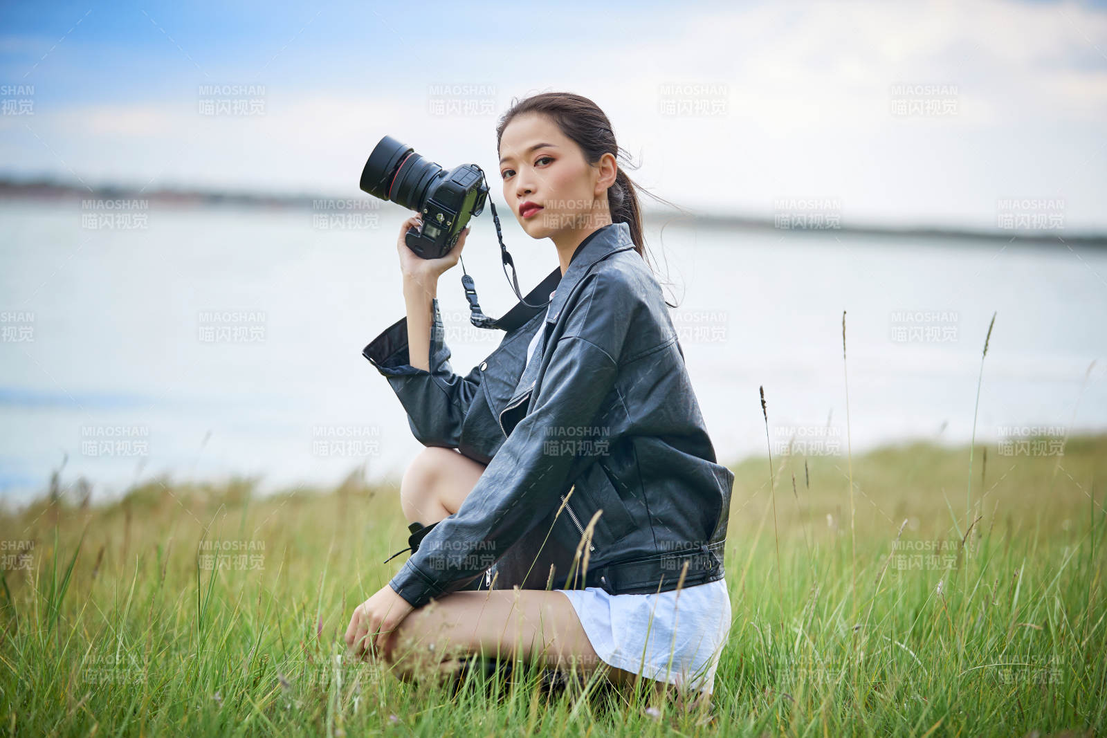 户外湖畔进行拍摄的亚洲青年女性摄影师图片