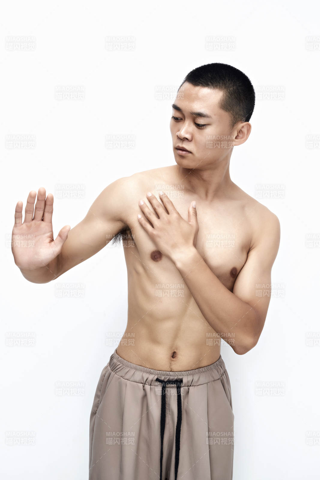 白色背景下展示健身预备拉伸动作的亚洲男性图片