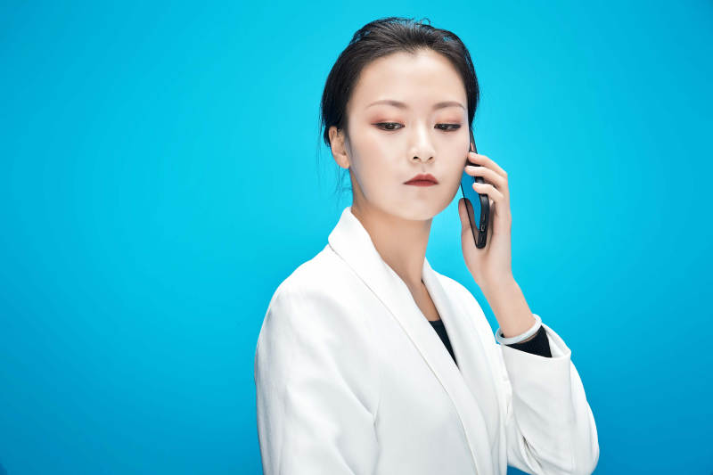 身穿西服拿着手机与文件夹的亚洲商务女士图片