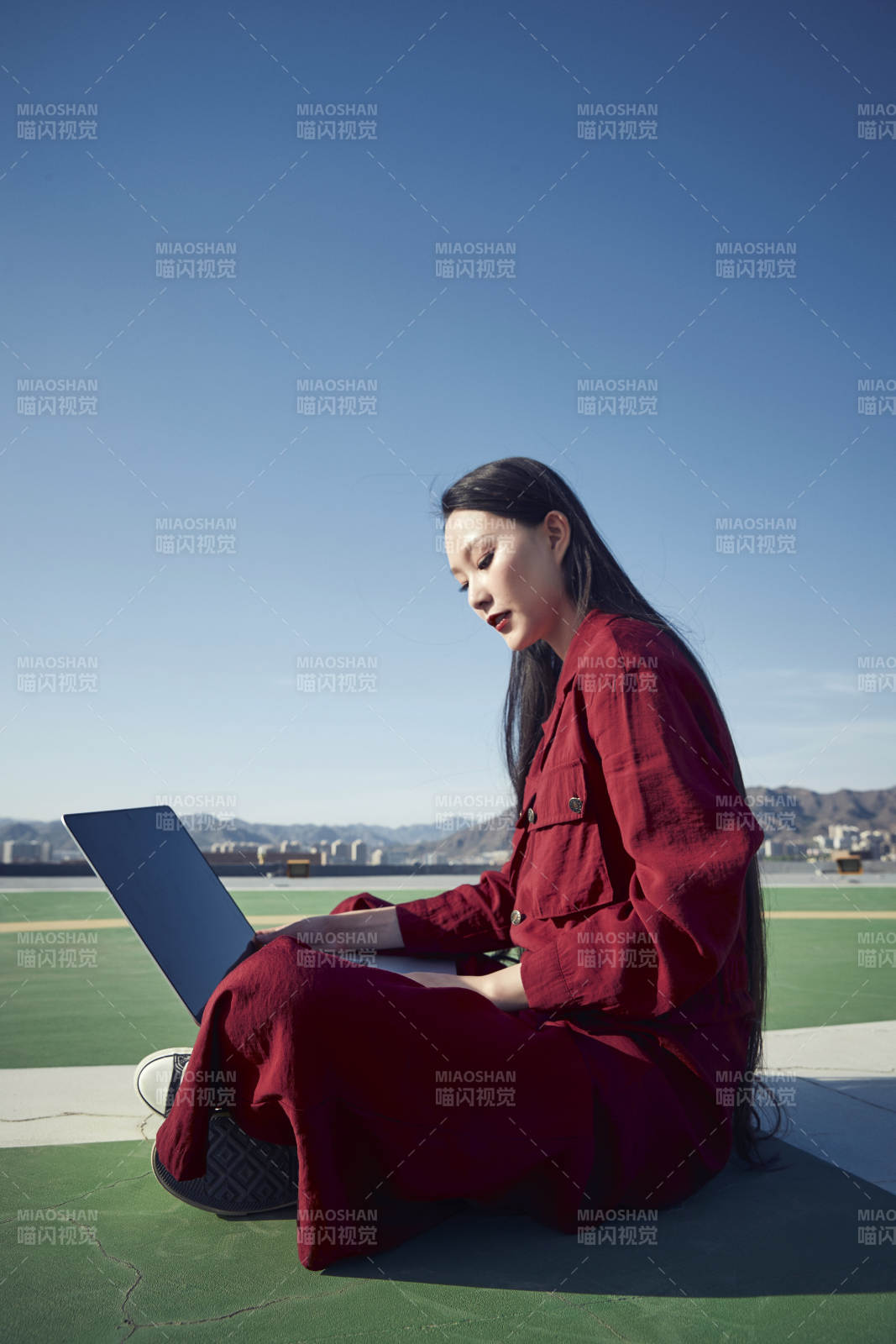 亚洲商务年轻女性在楼顶停机坪使用电脑办公图片
